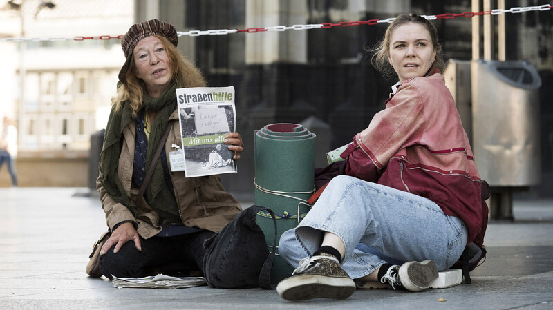 Monika Keller (Rike Eckermann, links) verkauft am Dom Obdachlosenzeitungen. Sie hilft Ella Jung (Ricarda Seifried), die gerade erst lernt, sich auf der Straße durchzuschlagen.
