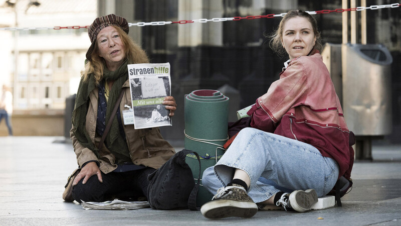 Monika Keller (Rike Eckermann, links) verkauft am Dom Obdachlosenzeitungen. Sie hilft Ella Jung (Ricarda Seifried), die gerade erst lernt, sich auf der Straße durchzuschlagen.