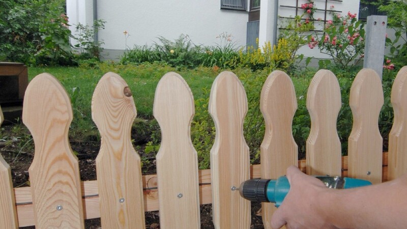 Ein Mann hat quer durch das Grundstück seines Nachbarn einen Holzzaun gebaut.