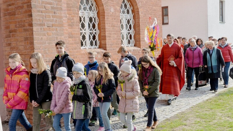 Kinder gingen mit ihren Palmbuschen vor Pfarrer Peter Häusler und dem Kirchenchor bei der Palmprozession in Atting.