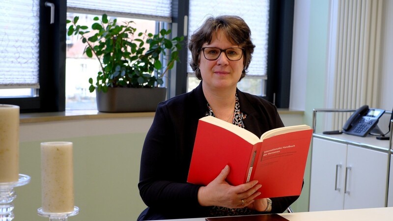 Standesamtsleiterin Karina Matz mit dem Internationalen Handbuch für Vornamen im Trauzimmer am Steiner Thor.