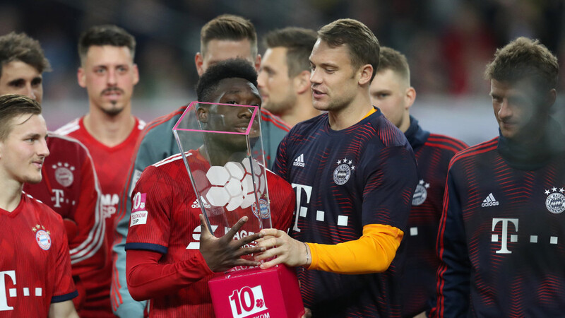 Triumph beim Telekom Cup: Manuel Neuer übergibt Alphonso Davies die Trophäe.