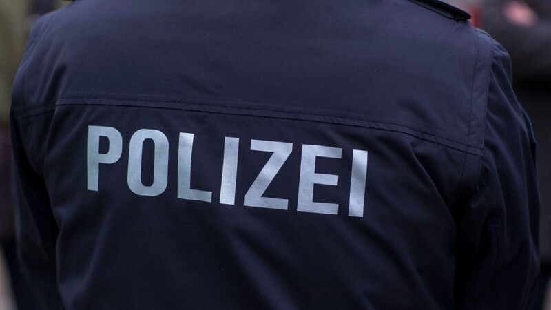 "Polizei" steht auf der Uniform eines Polizisten.