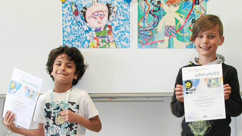 Der siebenjährige Ahmad und der zehnjährige Thimodan vor ihren von der Bundesjury ausgezeichneten Bildern "Schnee macht glücklich" und "Das Rutschenparadies".