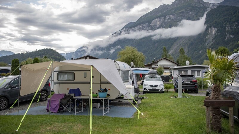 Stühle und ein Tisch stehen vor einem Wohnmobil auf dem ausgebuchten Campingplatz Aaregg am Brienzersee. Der Urlaub mit Wohnmobil ist in diesem Jahr besonders beliebt.