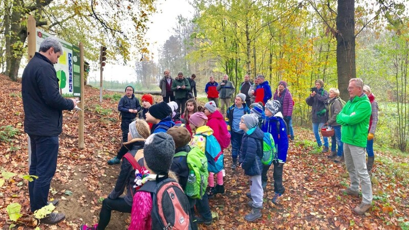 Bürgermeister Bauer (links) eröffnete im Beisein von Grundschülern der Klasse 2a und Projektbeteiligten den neu gestalteten Waldlehrpfad am Voithenberg.
