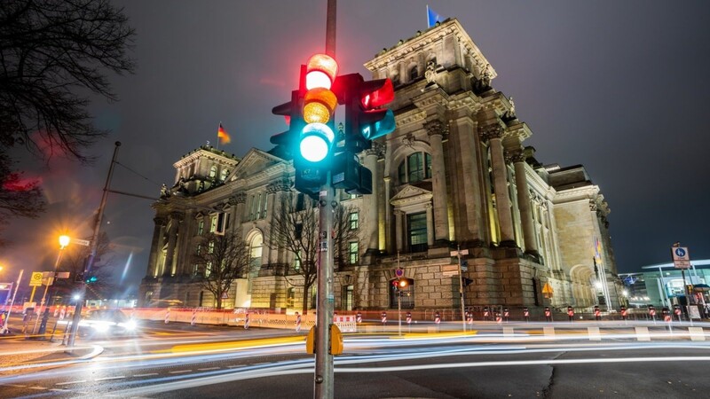 Eine Ampel leuchtet am Morgen vor dem Reichstagsgebäude in Berlin. Die Bildung der neuen deutschen Regierung wird auch im Ausland mit großem Interesse verfolgt.