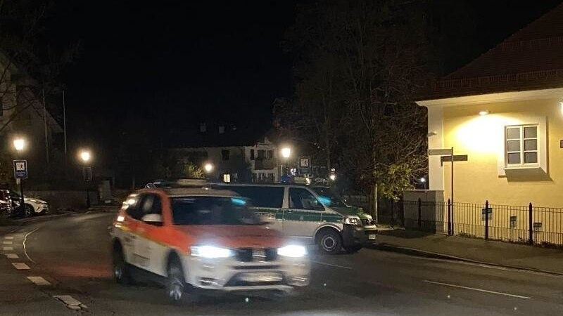 Ein Notarztfahrzeug und Polizeibeamte am Tatort der Geiselnahme in Tegernsee. Foto: Maxi Hartberger/Tegernseer Stimme/dpa