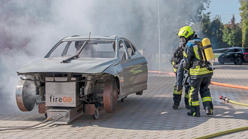 Das Fahrzeug ist von Auszubildenden des BWM-Werks Dingolfing gebaut worden. Bei der ersten Brandsimulation retten die Atemschutzträger der Feuerwehr Osterhofen, Markus Urlberger und Sebastian Ortner, einen etwa 80 Kilo schweren Dummy aus dem verrauchten Auto.
