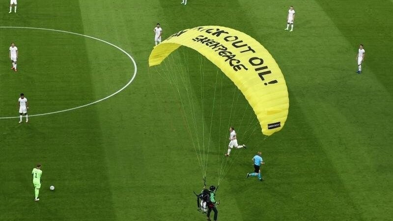 Ein Greenpeace-Aktivist landet auf dem Spielfeld.