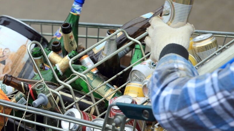 Leere Flaschen und Büchsen in einem Einkaufswagen