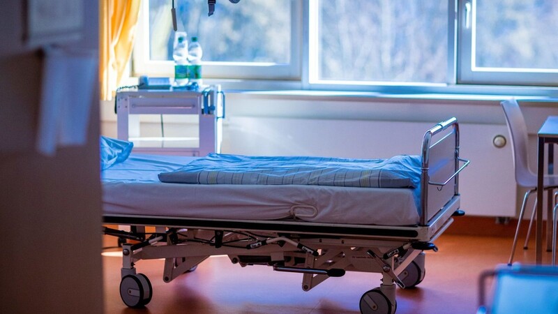 Ein leere Krankenbett steht in einem Behandlungszimmer in einem Klinikum.