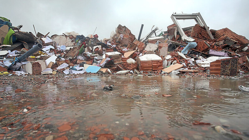 Die Trümmer des explodierten Hauses liegen auf einem Parkplatz nahe der Unglücksstelle im Regen.