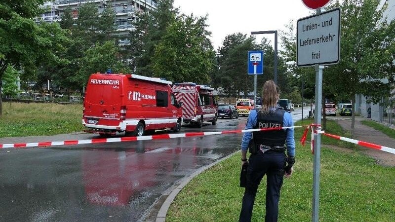 Eine Beamtin und Einsatzfahrzeuge der Feuerwehr auf dem Campus der TU Darmstadt.