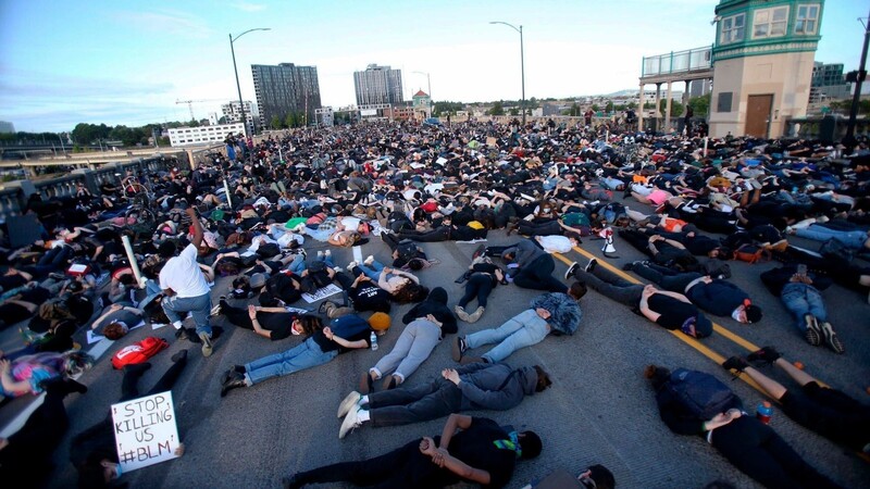 Portland: Die Demonstranten liegen bäuchlings mit den Händen auf dem Rücken neun Minuten lang auf dem Boden und symbolisieren damit die Zeit, die ein Polizist auf dem Hals von George Floyd kniete.