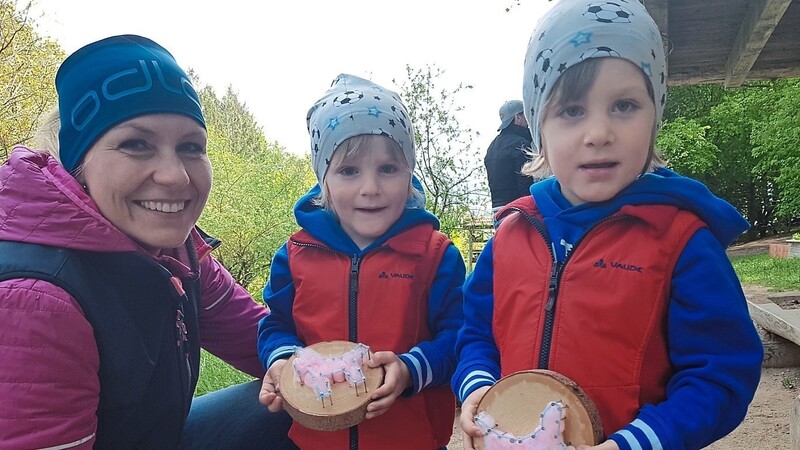 Waldkindergarten-Chefin Antonia Hastreiter mit zwei Kindern, die Einhörner mit Nägeln und Watte gebastelt haben.