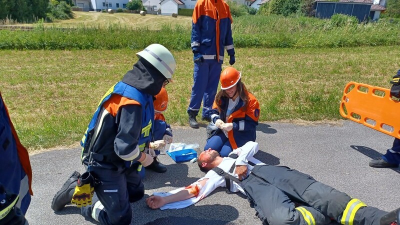 Erstversorgung eines verletzten Motorradfahrers am Unfallort.