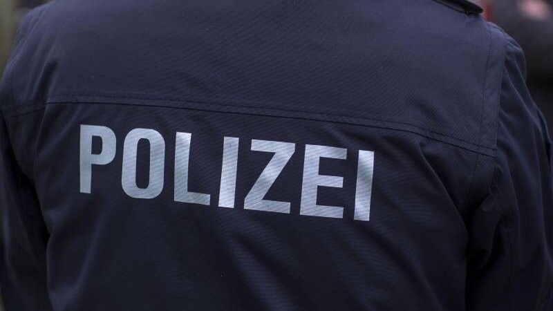 "Polizei" steht auf der Uniform eines Polizisten.