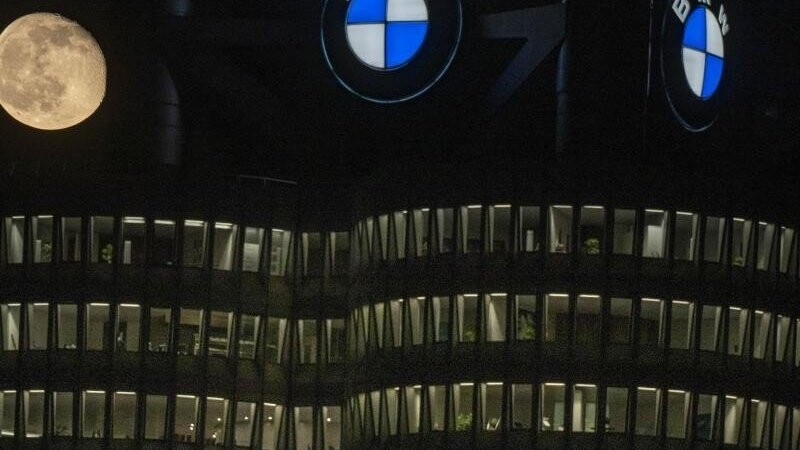 Der Mond steht hinter der BMW-Firmenzentrale in München.
