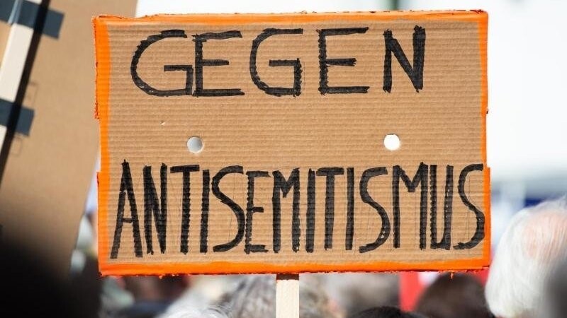 Ein Person hält bei einer Kundgebung eines Bündnisses gegen Antisemitismus ein Plakat mit der Aufschrift "Gegen Antisemitismus" in die Höhe. In Bayern wurden im ersten Halbjahr mehr antisemitische Vorfälle gemeldet. (Symbolbild)