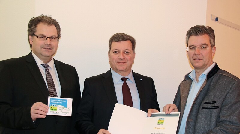 Werkleiter Stefan Kopp (links) und zweiter Bürgermeister Hans Schmalhofer (rechts) freuen sich über die Aushändigung der Umwelt-Urkunde durch Landrat Christian Bernreiter (Mitte).