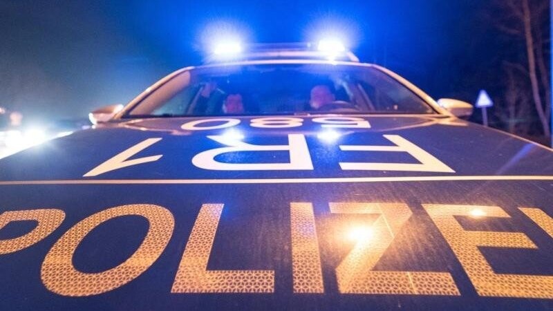 Ein Polizeifahrzeug steht während einer Verkehrskontrolle mit Blaulicht auf der Straße.