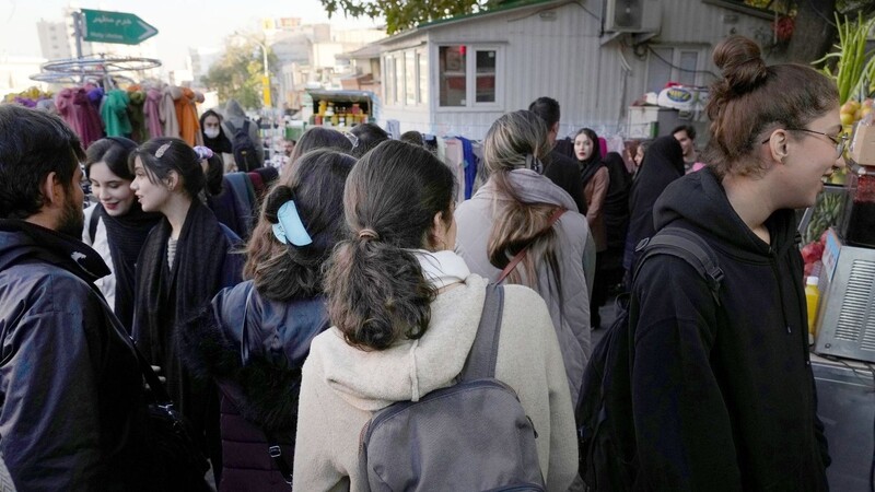 Iranische Frauen gehen ohne das vorgeschriebene islamische Kopftuch durch Teheran.