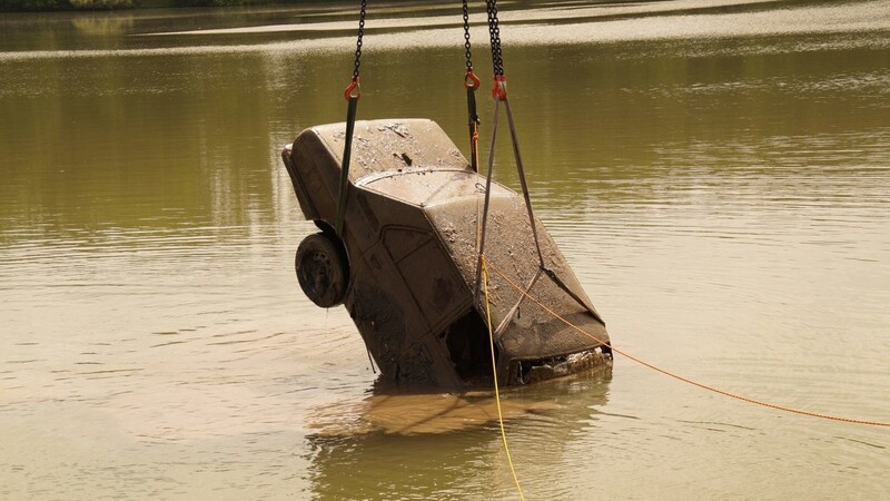 Per Kran wurde der alte Wagen aus dem Fluss gezogen und dann am Ufer mit einem Schlauch abgespritzt.