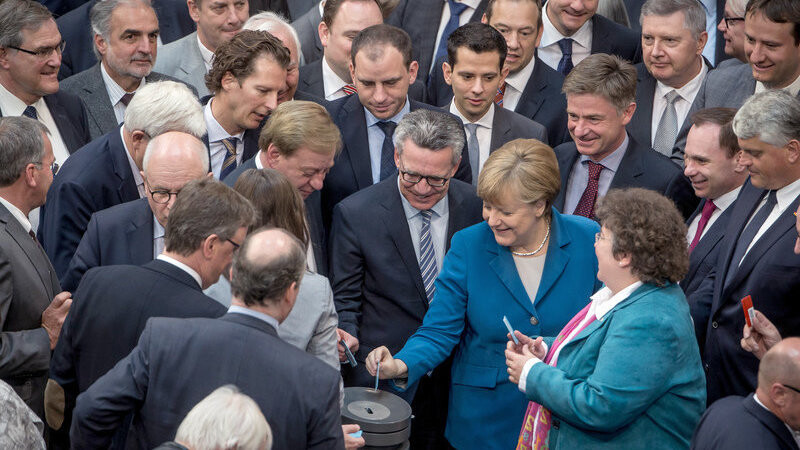 Bundeskanzlerin Angela Merkel (CDU) wirft neben Bundesinnenminister Thomas de Maiziere (CDU) am 13.05.2016 im Bundestag in Berlin ihre Stimmkarte bei der namentlichen Abstimmung zur Einstufung von Marokko, Tunesien und Algerien als sichere Herkunftsstaaten ein.