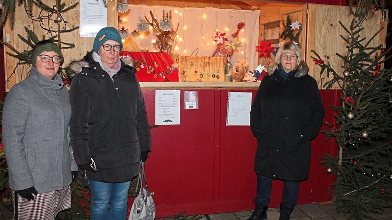 Familie Spichtinger (links) und Christine Kliem (rechts) haben eine Bude mit Weihnachtssternen und Schmuck aus Kaffeekapseln geschmückt.