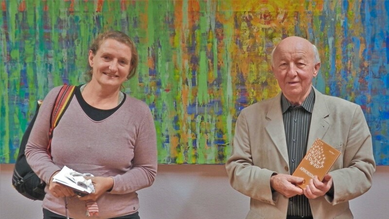 Autor Anton Halser und Musikerin Brigitte Gray bei der Buchvorstellung im Dieter-Görlitz-Saal vor einem Gemälde von Werner Rickinger.