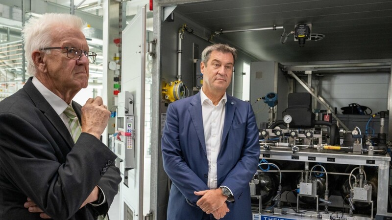Die Landeschefs Kretschmann (l.) und Söder lassen sich in einem Ulmer Forschungszentrum eine Wasserstofftankstelle erklären.
