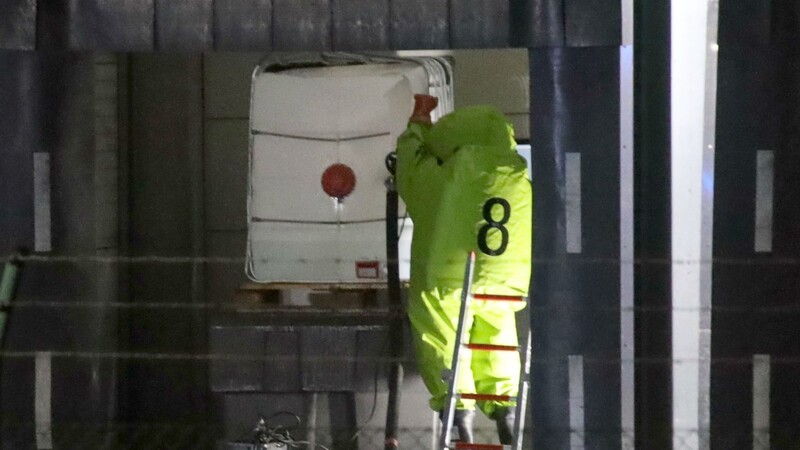 Ein Feuerwehrmann in einem Chemikalienschutzanzug arbeitet an einer Einsatzstelle. Bei einer Spedition war am Mittwochabend Flusssäure ausgelaufen.