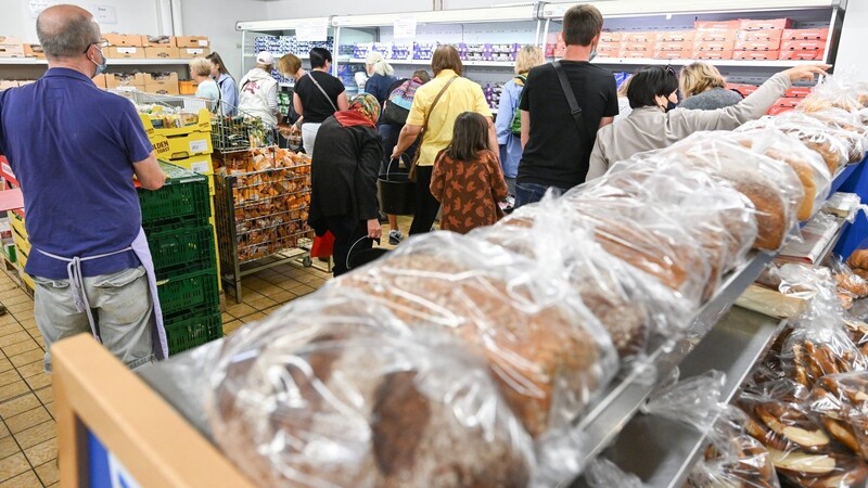 Menschen kaufen in einem Tafelladen Lebensmittel ein. Die Zahl der Menschen, die von Armut bedroht sind, ist deutlich angestiegen.