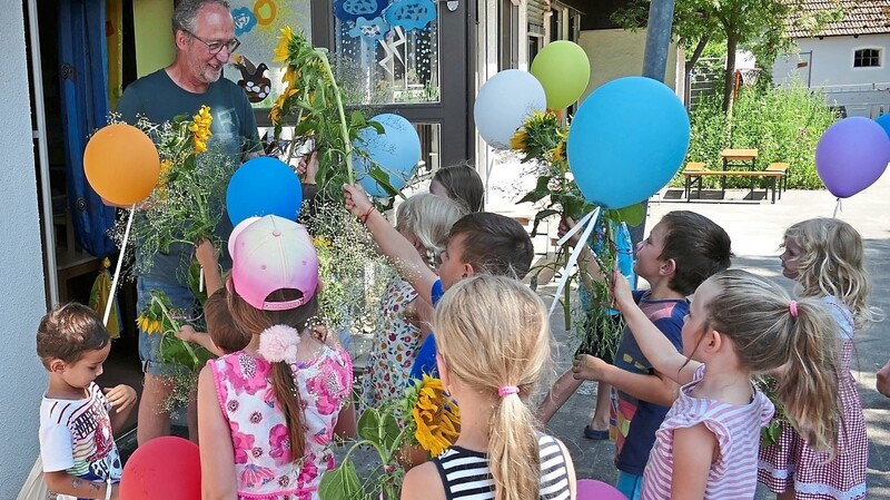 Mit Sonnenblumen und Luftballons überraschten die Kinder den scheidenden Kinderhausleiter.