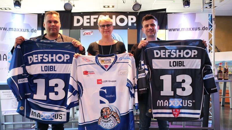 Thomas Gross (Geschäftsführung DefGroup), Gaby Sennebogen (Geschäftsführerin Straubing Tigers) und Ivan Lukanov (Geschäftsführer von Maxxus) stellen die Trikots für die anstehende Spielzeit vor.