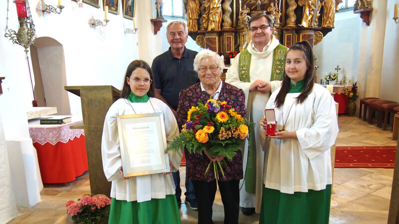Amalie Bartl erhielt ihre Auszeichnung von Pfarrer Pater Paul Mrotek. Pfarrgemeinderatsvorsitzender Karl-Heinz Richter gratulierte.