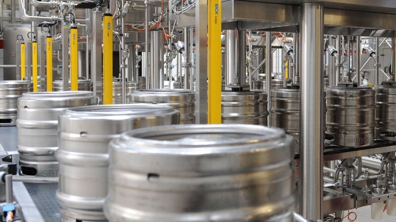 Bier wird in einer Brauerei in einer Abfüllanlage in Bierfässer gefüllt.