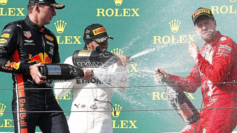 RICHTIG NASS GEMACHT wird Sebastian Vettel (r.) auf dem Hongaroring von Grand-Prix-Sieger Lewis Hamilton und Max Verstappen (l.).