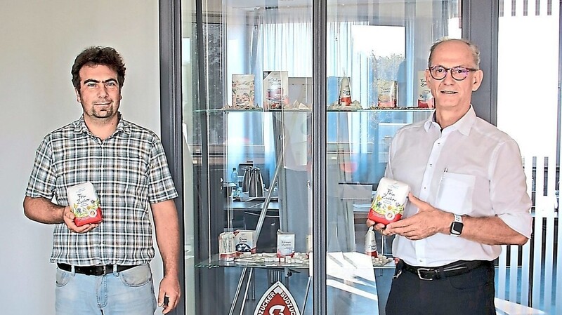 Benjamin Kirchberger, Leiter der Rohstoffabteilung (l.), und Regionalleiter Wolfgang Vogl mit Packungen der limitierten Auflage des Blühwiese-Zuckers von Südzucker.