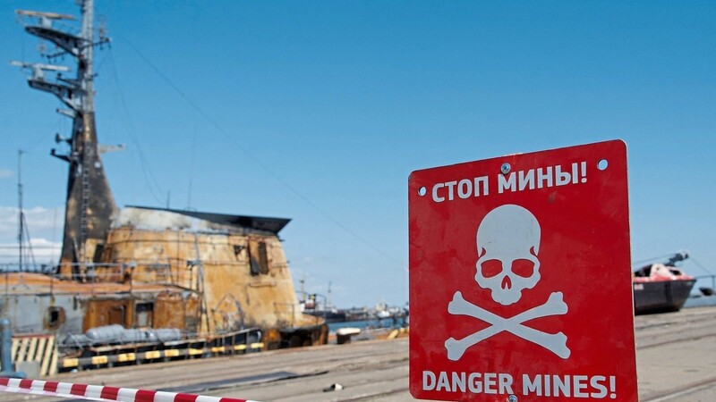Am Hafen der zerstörten ukrainischen Stadt Mariupol warnt ein Schild vor Minen.