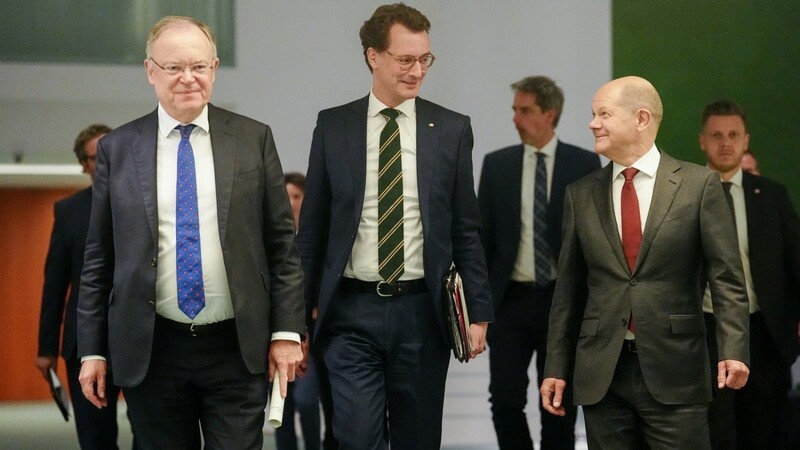 Bundeskanzler Olaf Scholz (r), Stephan Weil (l), Ministerpräsident von Niedersachsen, und Hendrik Wüst, Ministerpräsident von Nordrhein-Westfalen, kommen nach der Ministerpräsidentenkonferenz zur Pressekonferenz.