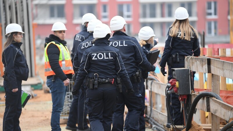 Beamte des Zolls gehen während eines Einsatzes über eine Großbaustelle in Frankfurt (Archivfoto). Sie gehen gegen illegale Beschäftigung und Sozialleistungsmissbrauch, aber auch gegen Mindestlohnverstöße vor.