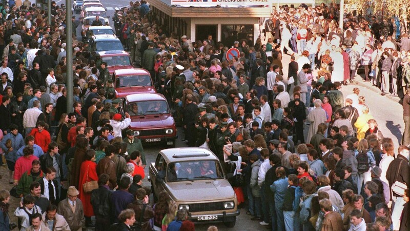 10. November 1989: Die Mauer ist gefallen. Eine Fahrzeugkolonne schiebt sich in Richtung West-Berlin vorbei am Checkpoint Charlie.
