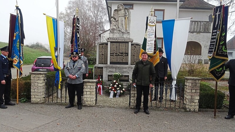 Martin Söll (links), Bürgermeister Schott und Fahnenabordnungen am Kriegerdenkmal.
