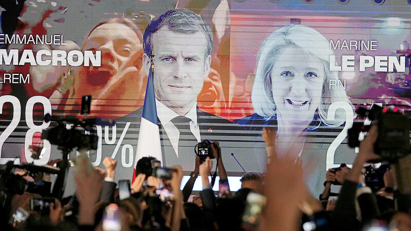 Ein Bildschirm zeigt die ersten Hochrechnungen für Macron und Le Pen am Wahlabend.
