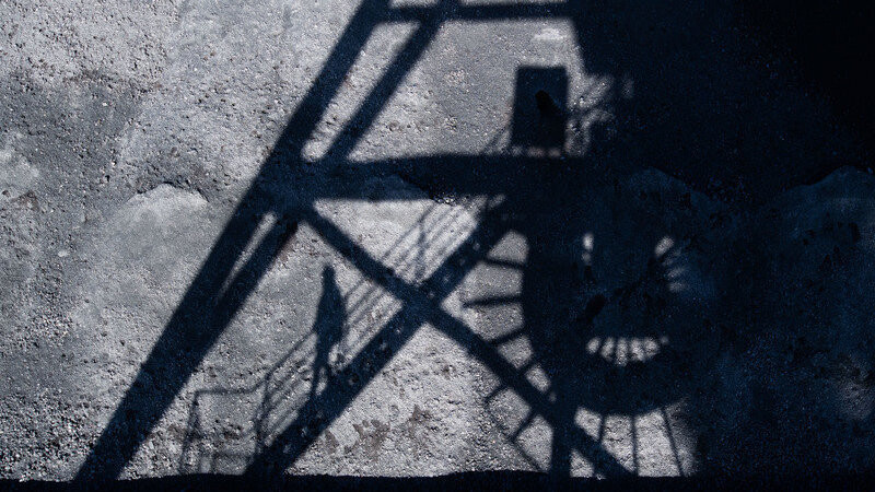 Steinkohle lagert im Kohlehafen vom Kohlekraftwerk Mehrum im Landkreis Peine, als der Schatten eines Mitarbeiters auf einer Brücke auf die Kohle fällt (Symbolbild).