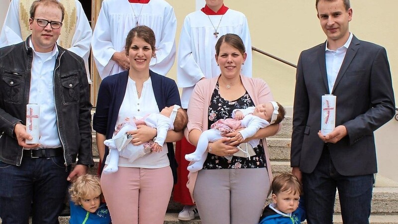 Pater Raymund und die Familien Müller (l.) und Simeth (r.) freuen sich über zwei neue Mitglieder in der Kirchengemeinde.
