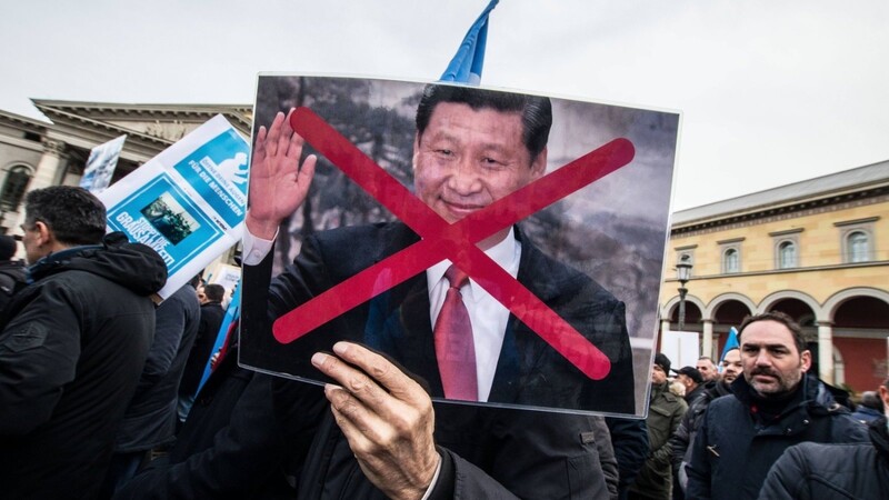 In München leben viele Exil-Uiguren. Hier protestieren sie 2019 mit einem Foto des Präsidenten Xi Jinping gegen die Verfolgung dieser ethnischen Gruppe in China.