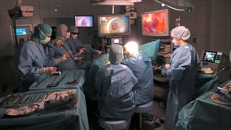 Höchste Konzentration im OP am Regensburger Caritas-Krankenhaus St. Josef: Bei einer TaTME-Operation arbeiten zwei Endoskopie-Teams gleichzeitig vom Bauchraum und dem After aus. Die Bilder auf den Monitoren sind nicht etwa unscharf, sondern dreidimensional, weshalb die Beteiligten 3D-Brillen tragen.